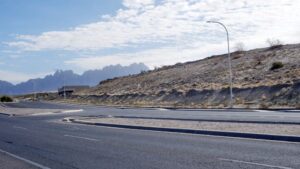 A street with a hill and mountains behind it.
