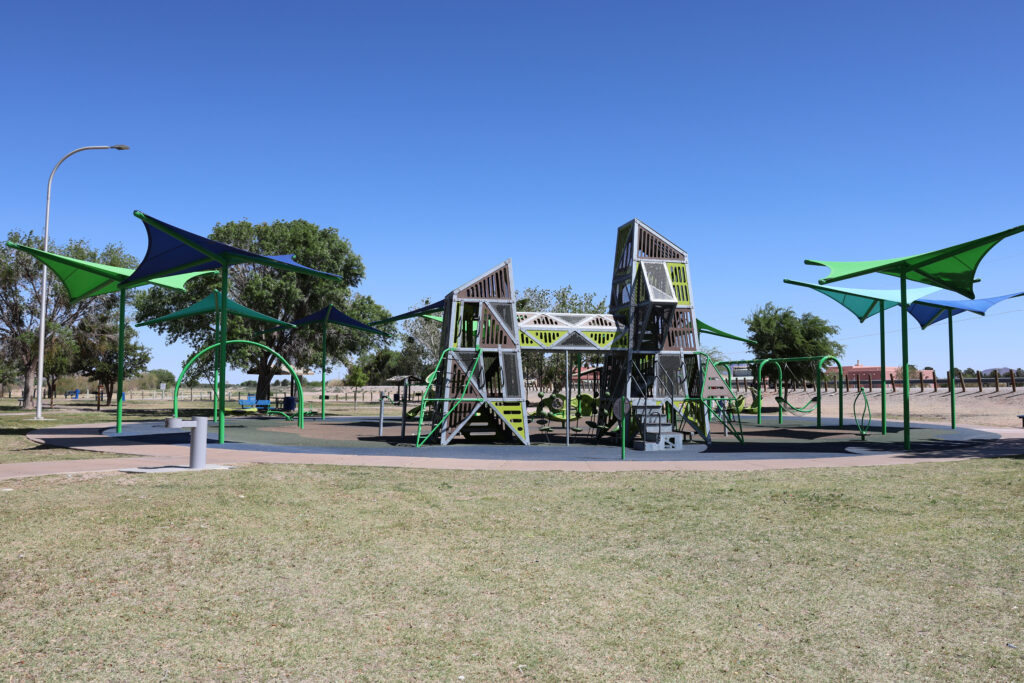 Full Playground with structures at La Llorona Park over play equipment and soft surface.