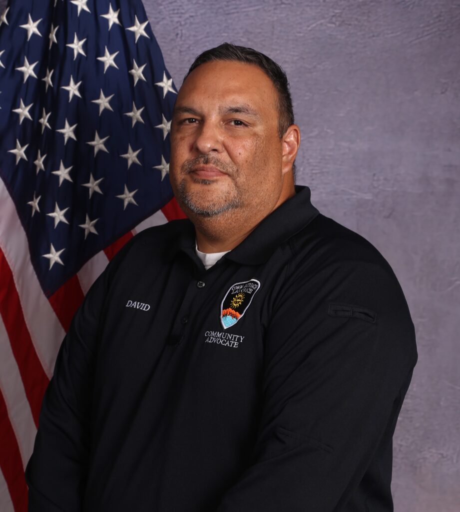 A community outreach advocate with the American flag in the background.