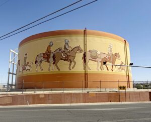 Water tank with men riding horses painted on it.